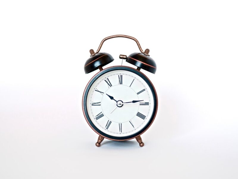 round black and white analog alarm clock