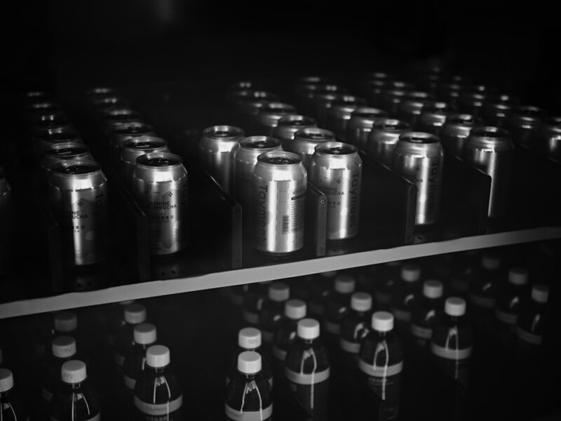 Rows of aluminum cans and glass bottles in darkness