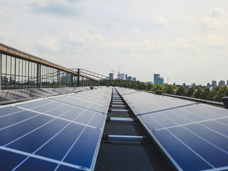 Zonnepanelen op het dak van een bedrijfspand met daarachter een loods