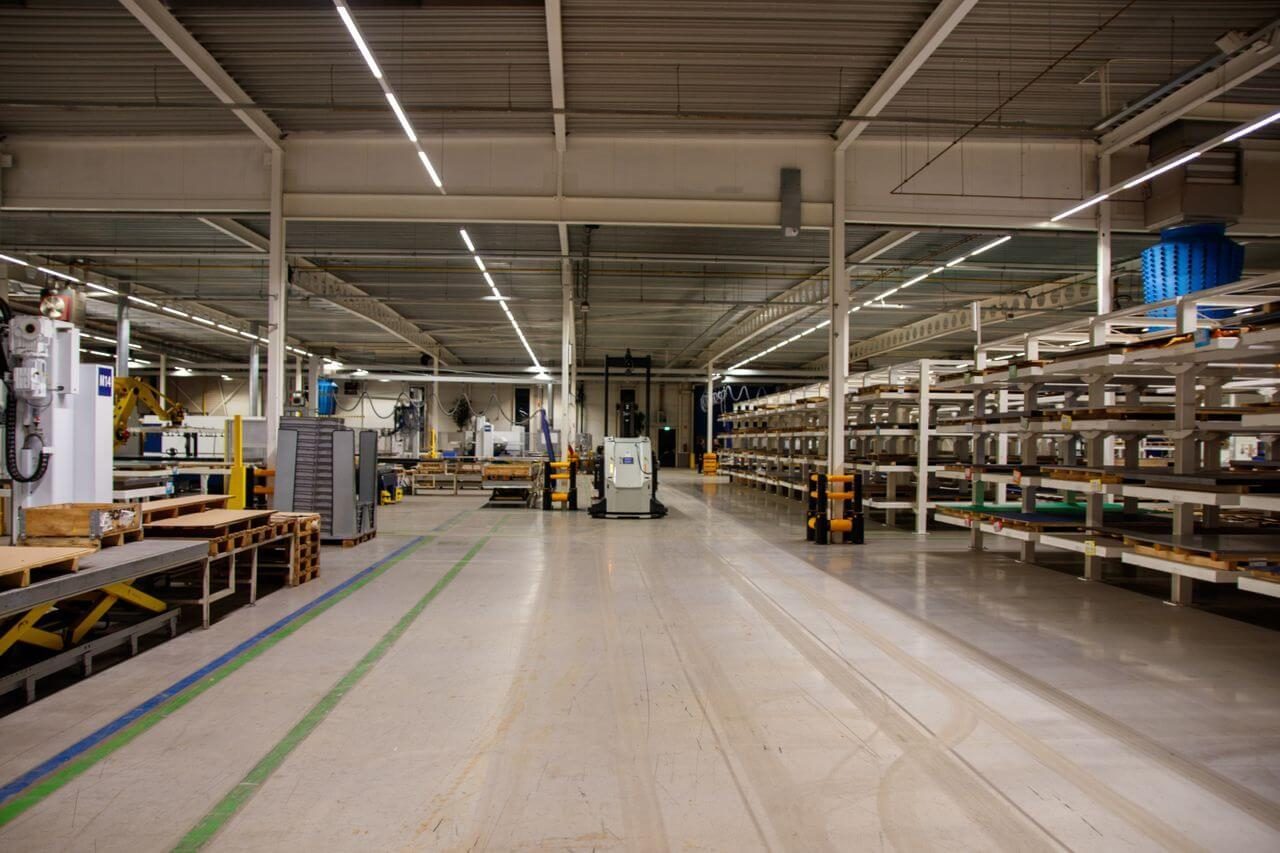 Opgeruimde bedrijfshal met stellingen en gemarkeerde looppaden