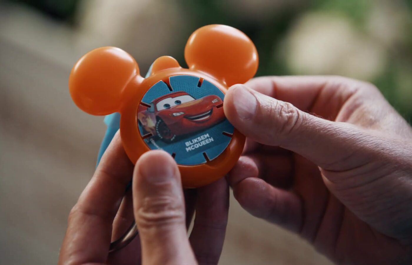 Hand houdt een oranje Diskey met Bliksem McQueen vast uit de spaaractie van Albert Heijn
