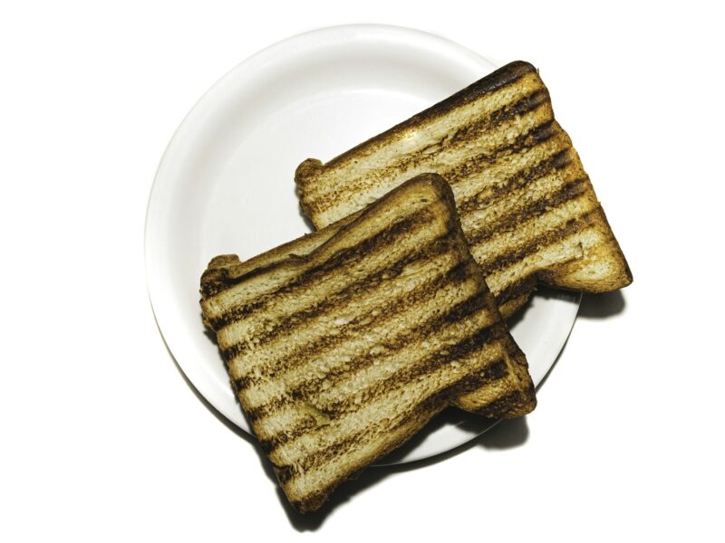 Sneetjes brood op een snijplank naast een broodrooster