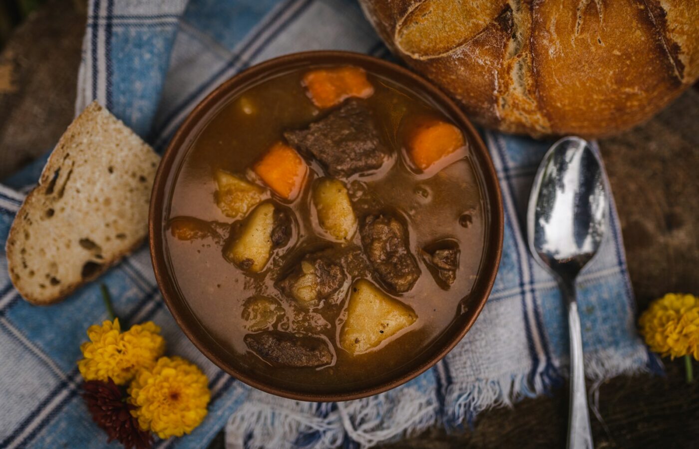 Een slowcooker met stoofvlees en uien in donkere saus