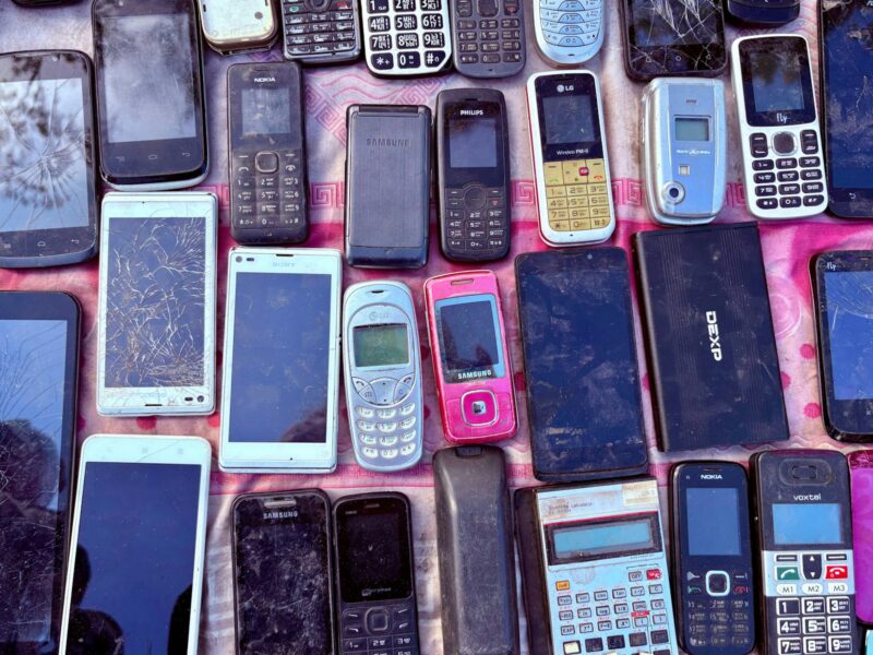 Een paar oude smartphones naast elkaar in een houten la