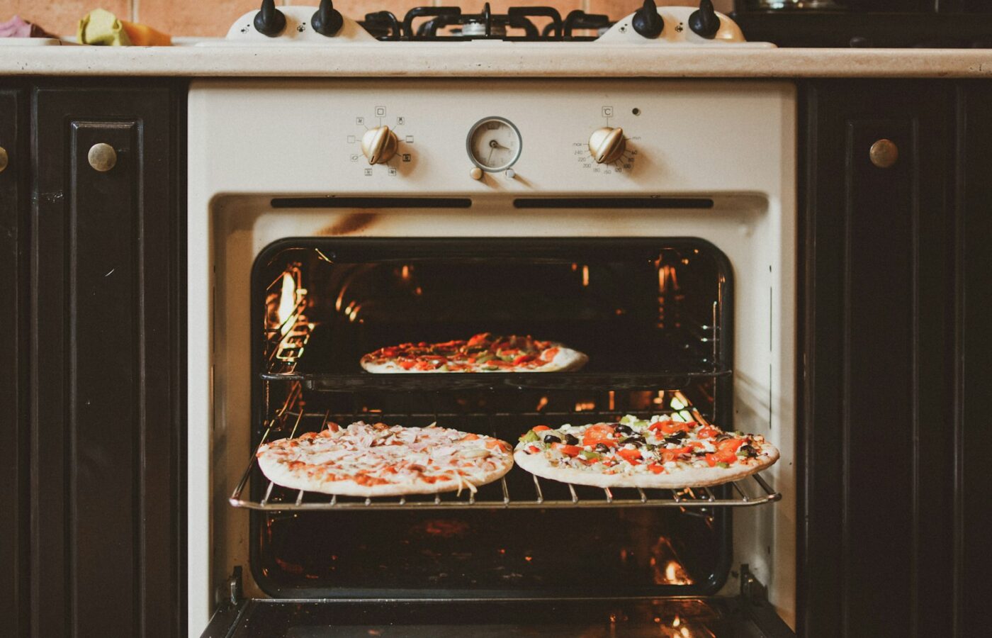 Iemand maakt de binnenkant van een oven schoon met een doek