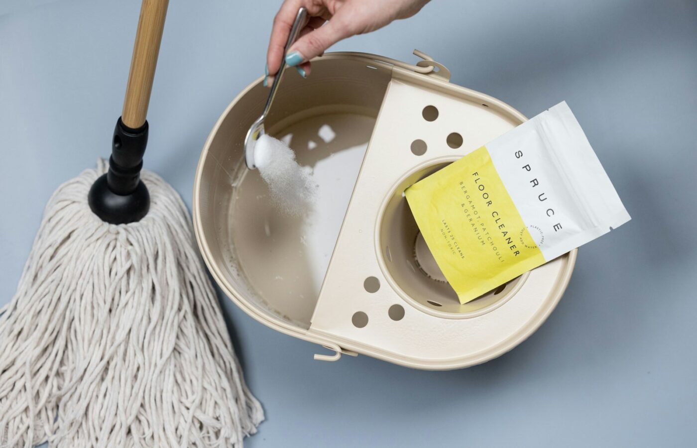 Een emmer met dweil op een schone houten vloer