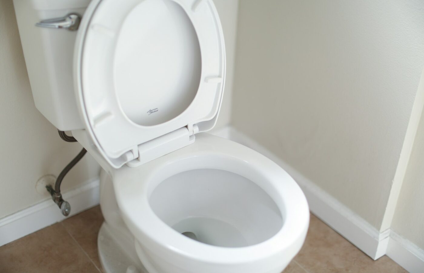 Een schone witte wc in een lichte badkamer